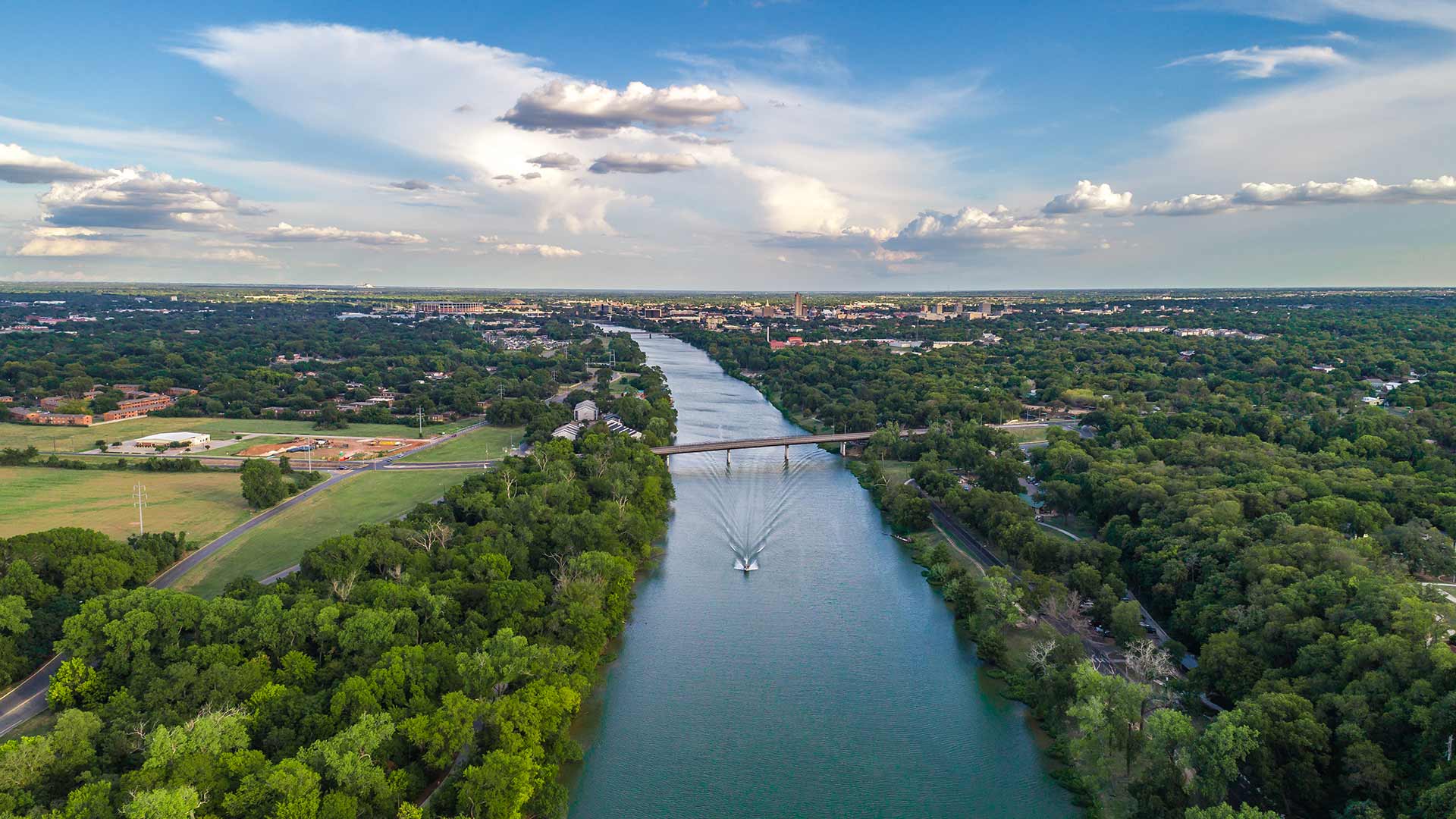 Aerial view of the Brazos River and Waco, Texas skyline in the background.
