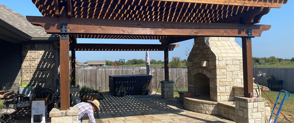 Green Ackors Landscaping & Irrigation professional installing pavers under pergola for patio in China Spring, TX.
