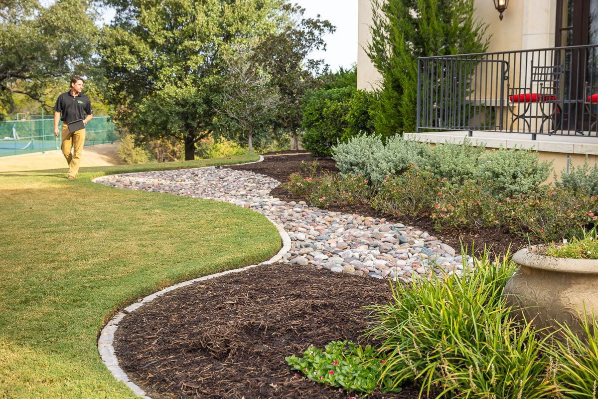 Account manager inspecting residential property landscape beds mulch plants 2