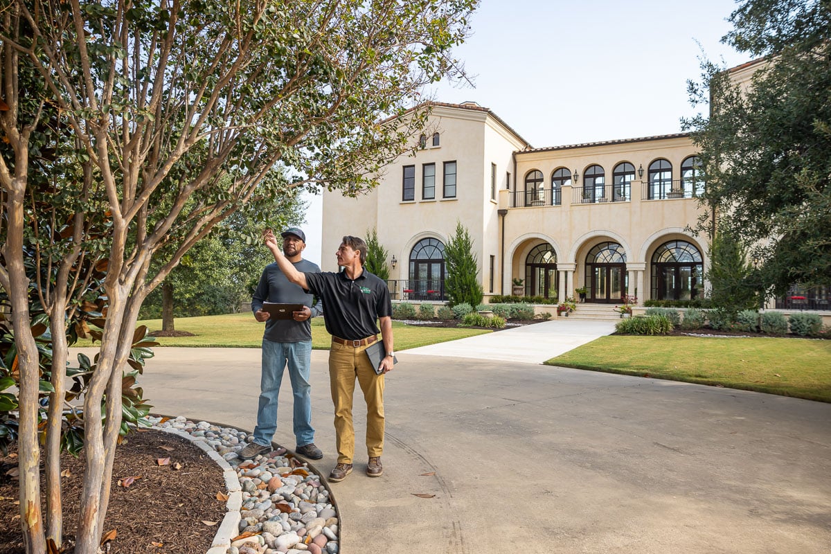 Account manager inspecting residential property with operations manager trees 