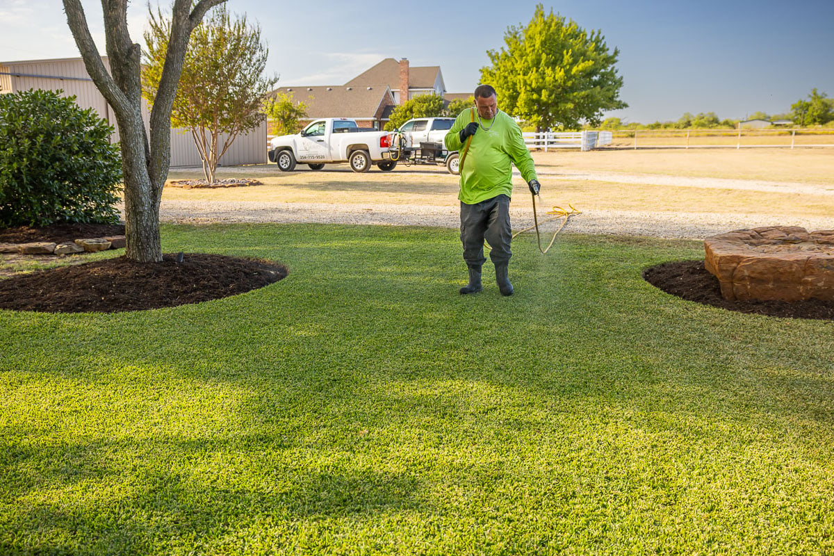 Crew lawn care treatment spraying green lawn 1