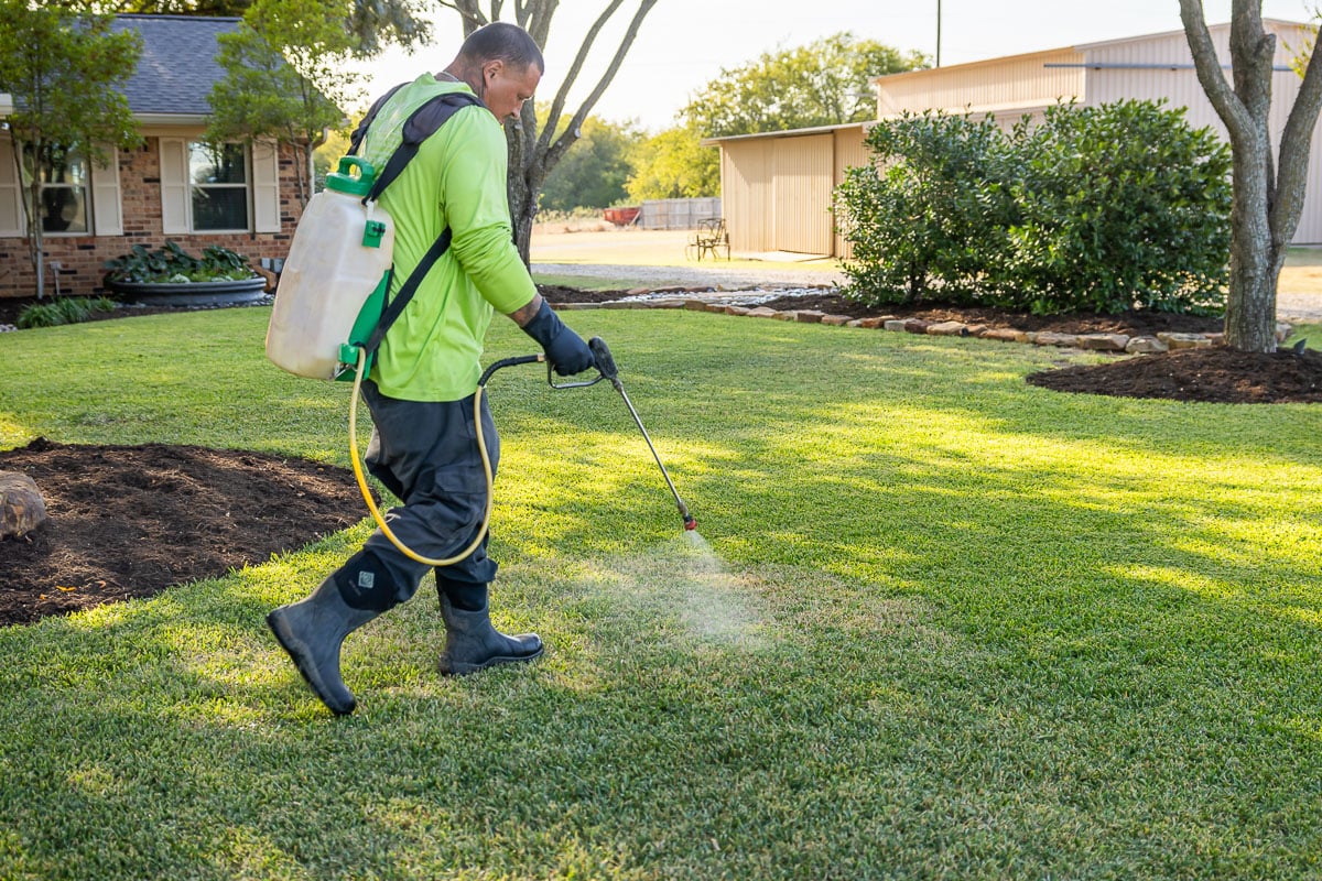 Crew lawn care treatment spraying green lawn 12