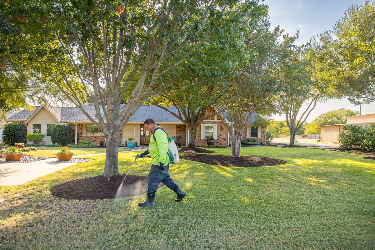 Crew lawn care treatment spraying green lawn 17