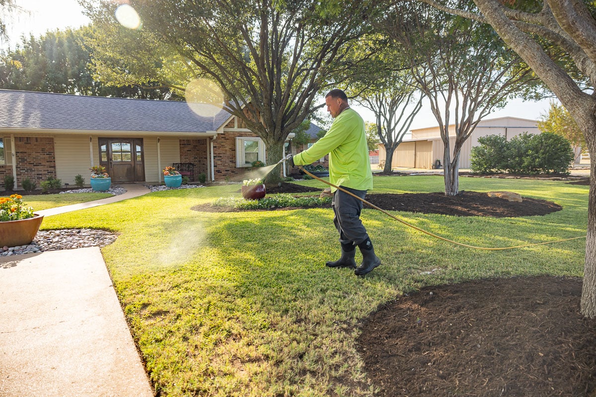 Crew lawn care treatment spraying green lawn 5