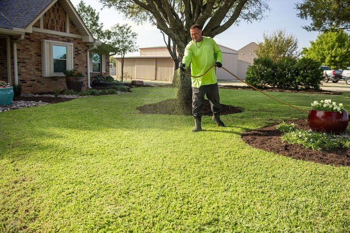 Crew lawn care treatment spraying green lawn 8