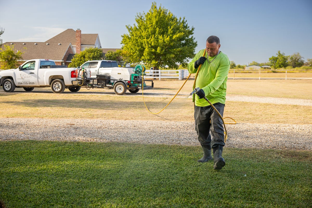 Crew lawn care treatment spraying green lawn