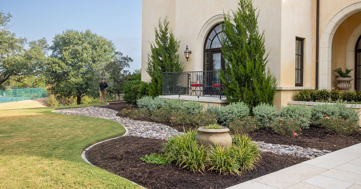 Account manager inspecting residential landscape beds