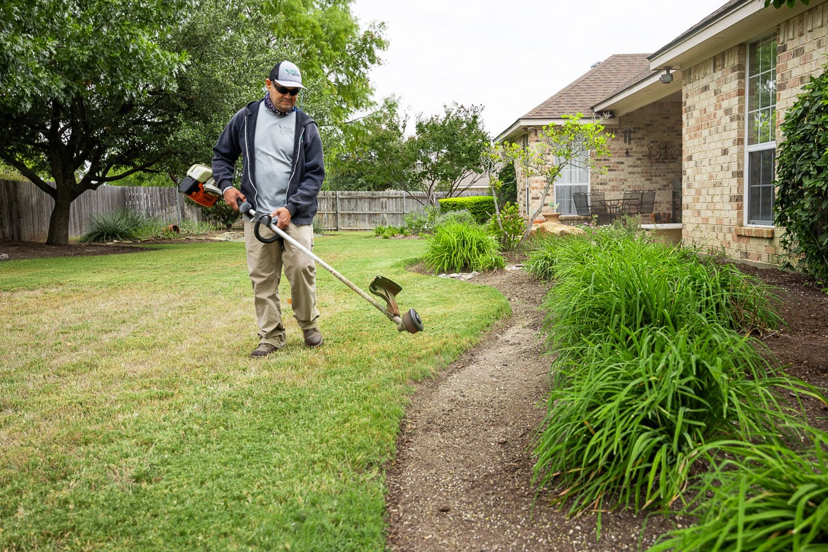 Landscape maintenance crew edging landscape beds 