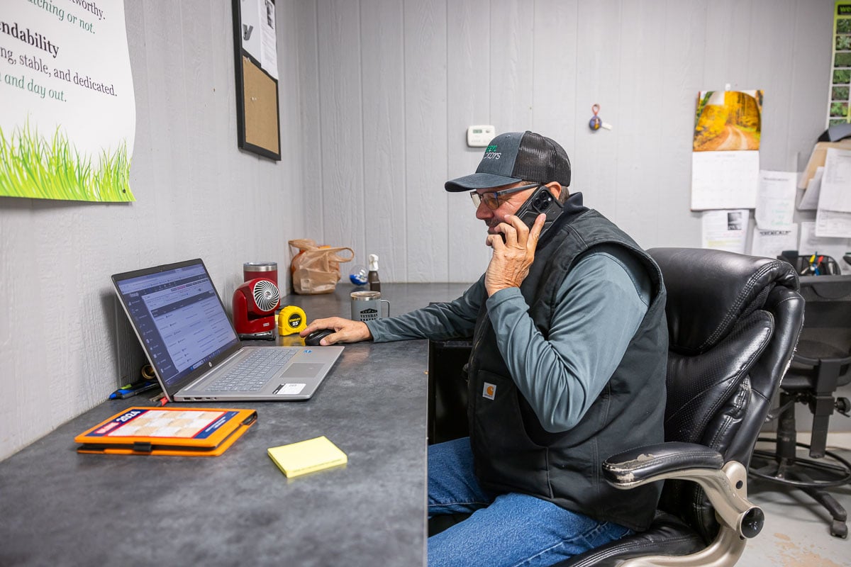 Manager at phone on computer
