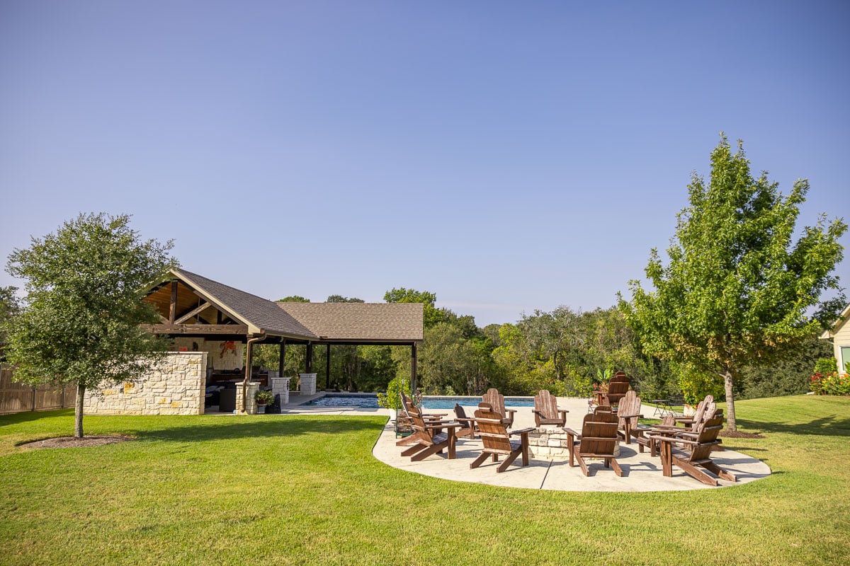 Residential landscape maintenance backyard green lawn fire pit pool patio