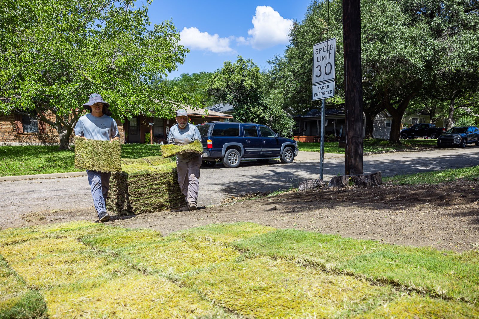 Residential maintenance crew laying sod