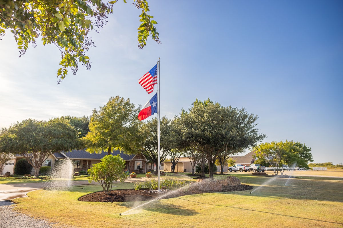 Residential maintenance irrigation sprinklers watering lawn flags 