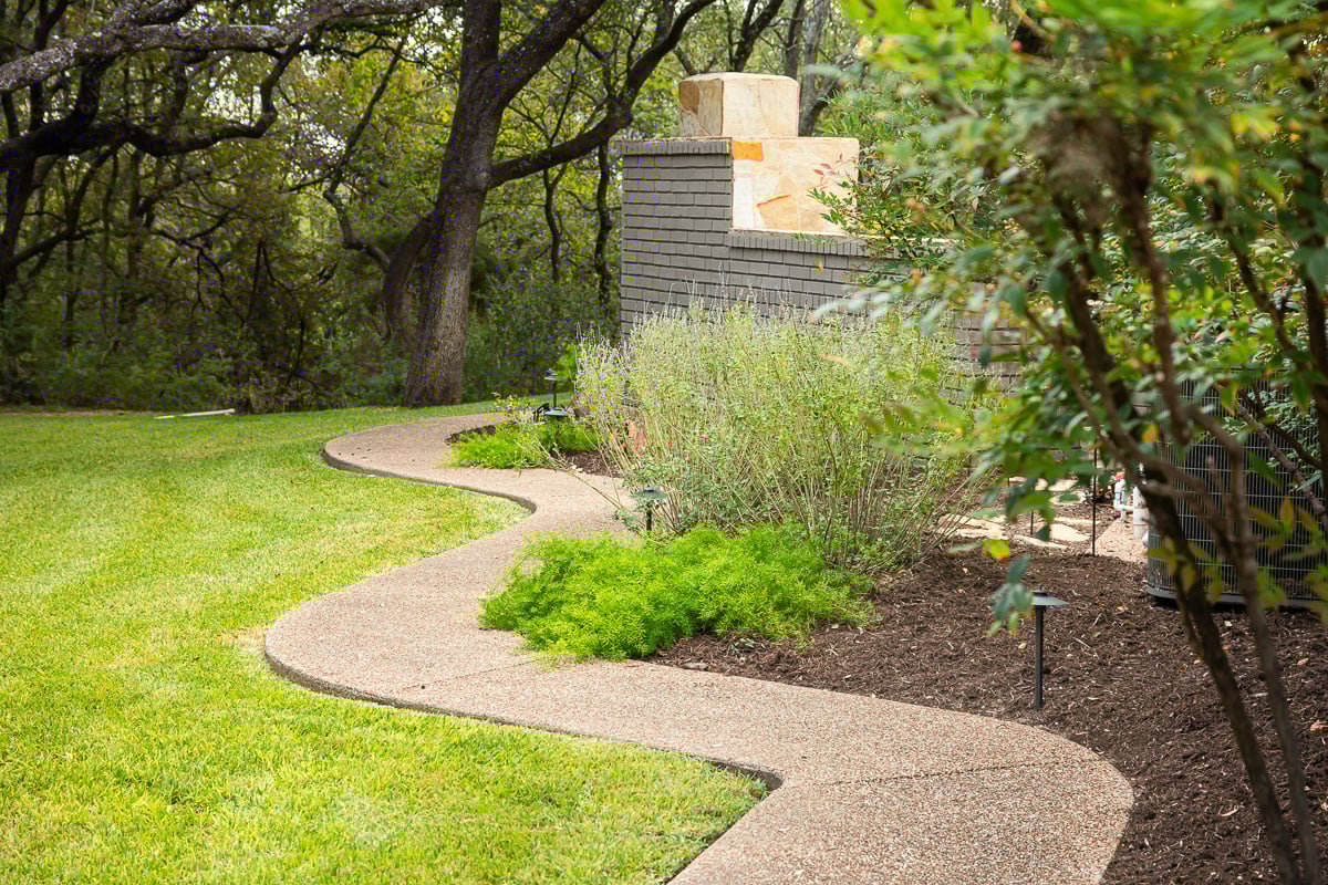 Sidewalk leading backyard landscape beds maintenance 
