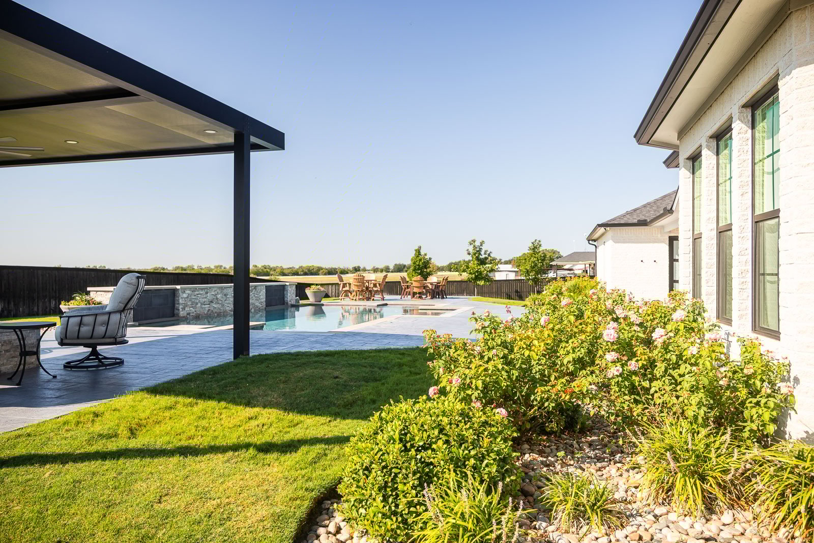 back of house landscape beds green lawn pool patio pergola