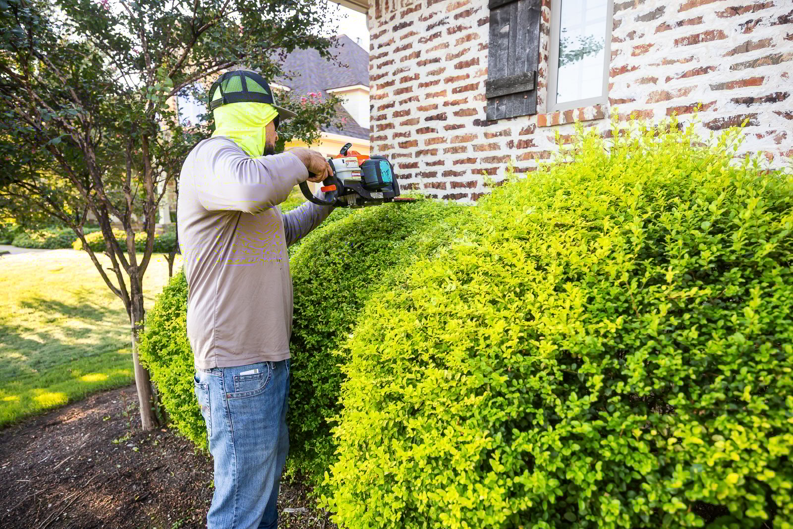 front of house landscaping crew maintenance trimming bushes 1