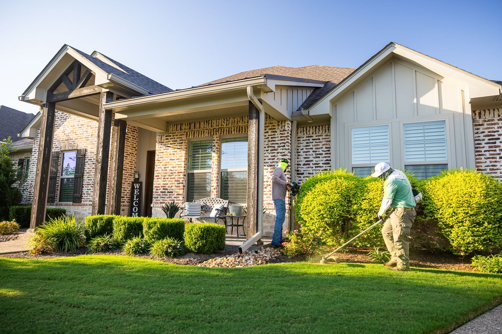 front of house landscaping crew maintenance weed eating 6