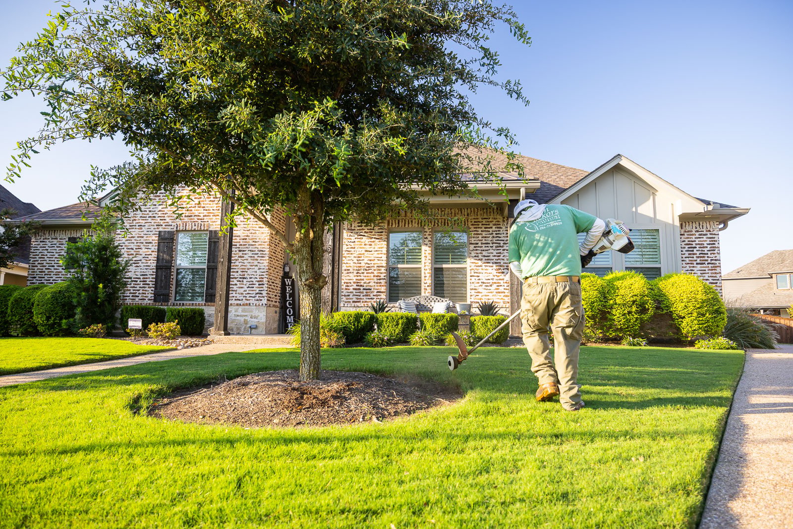 front of house landscaping crew maintenance weed eating8