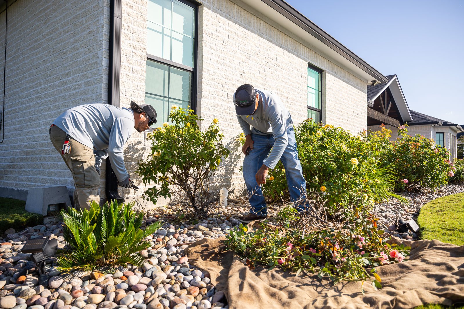maintenance crew cleaning up landscape beds