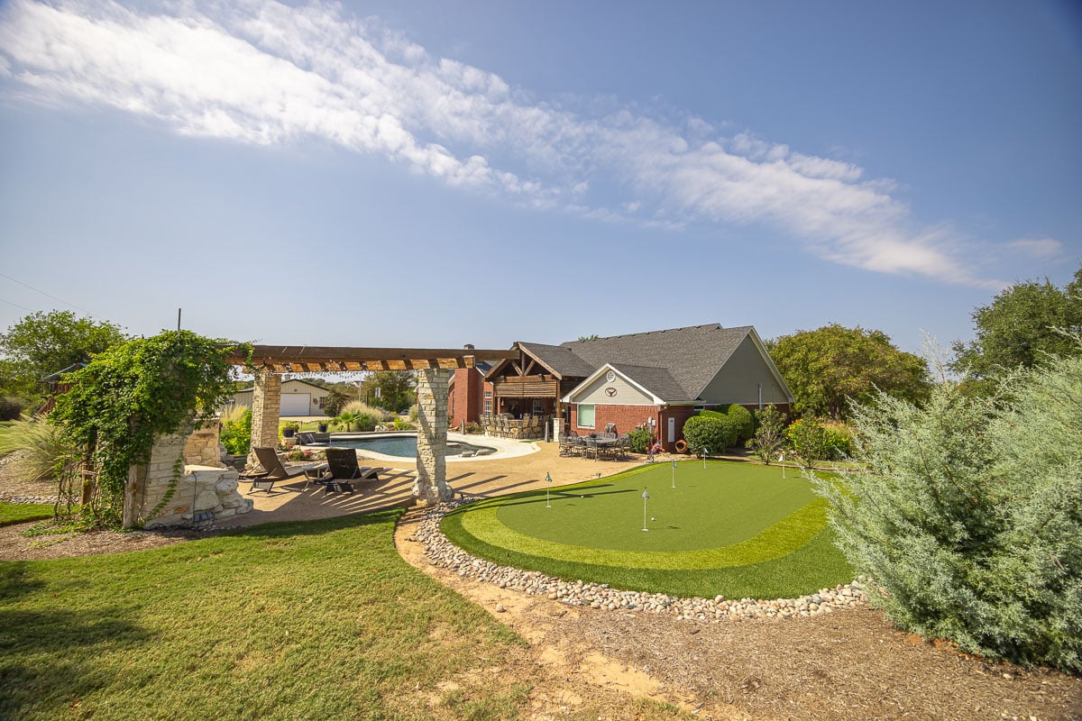 putting green artificial turf backyard green lawn pool patio pergola
