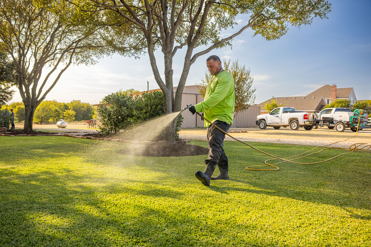 Crew lawn care treatment spraying green lawn 2