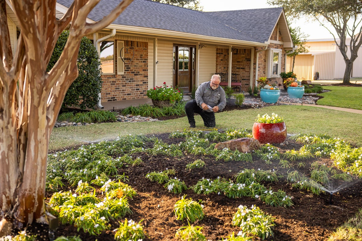 Residential maintenance irrigation sprinklers watering lawn technician adjusting sprinkler heads