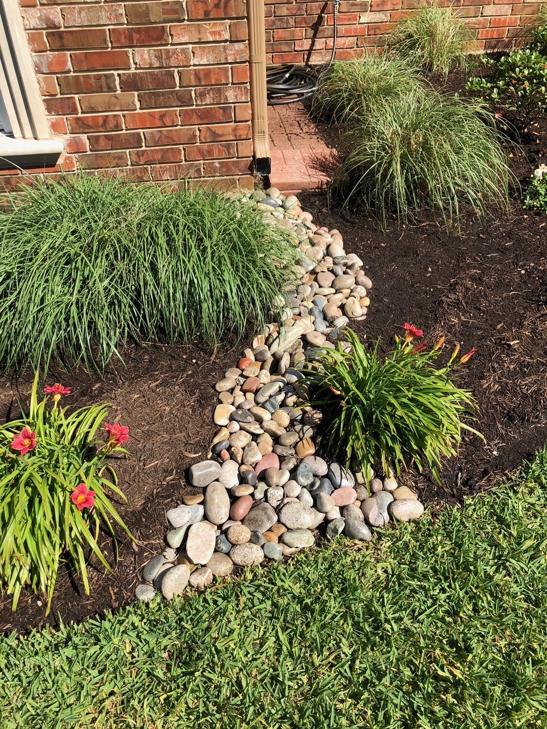 https://47688315.fs1.hubspotusercontent-na1.net/hubfs/47688315/downspout%20drainage%20cobble%20mulch%20plant%20bed%20home.jpeg