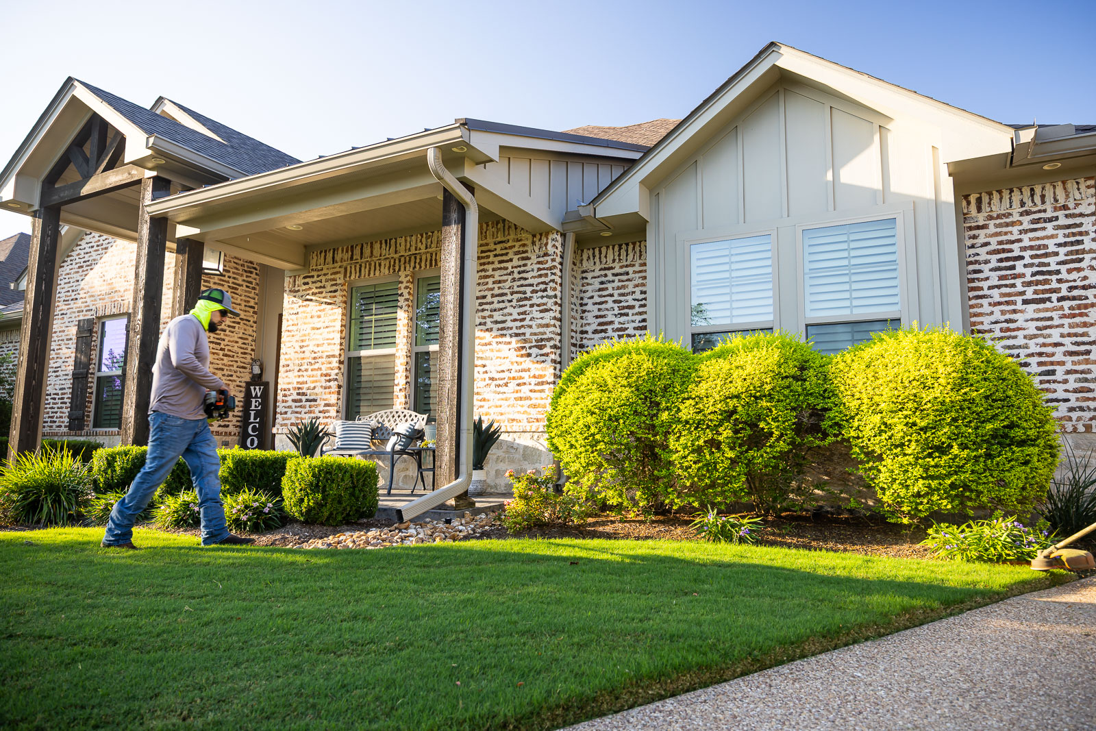 front of house landscaping crew maintenance weed eating 4