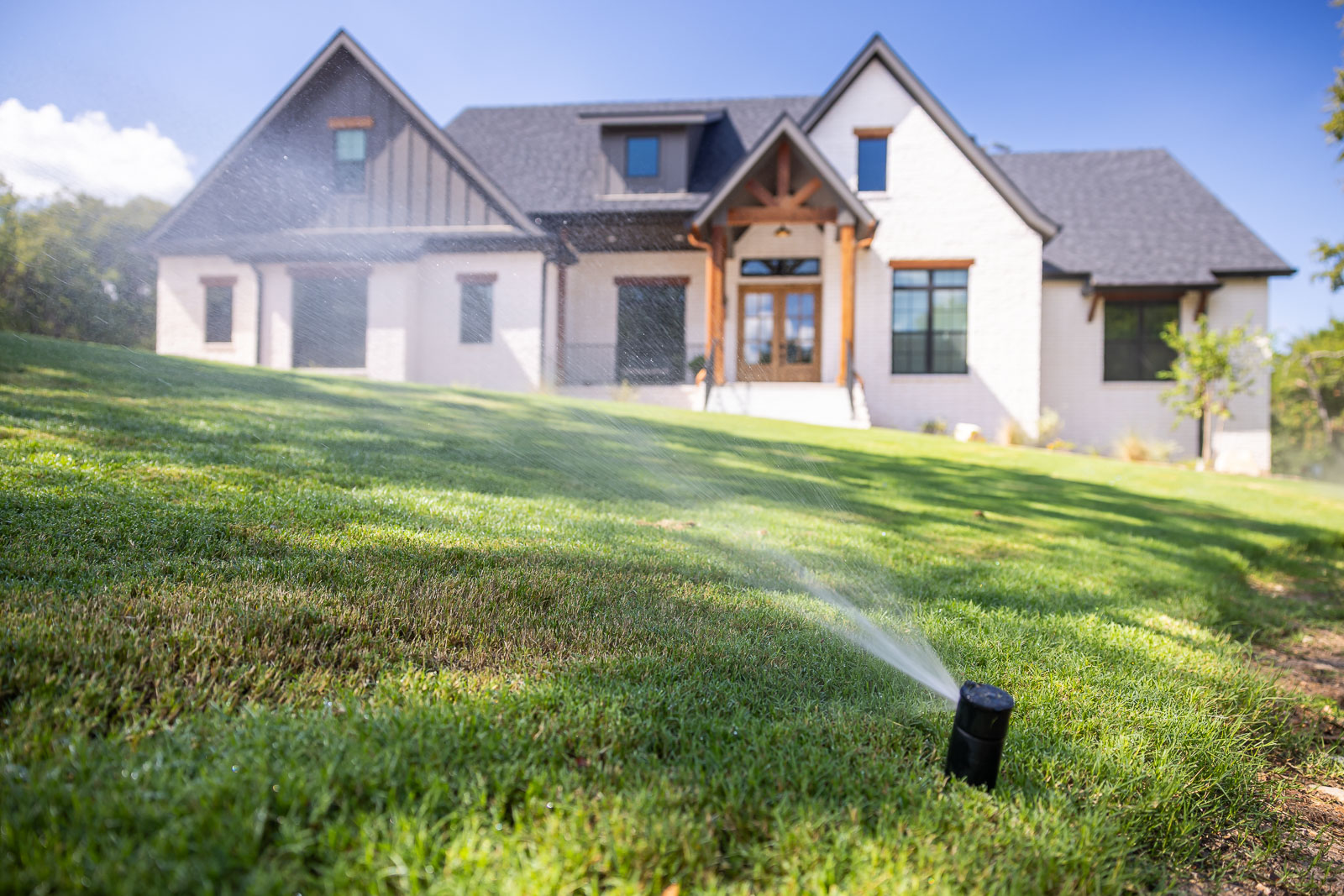 irrigation system watering lawn front of house