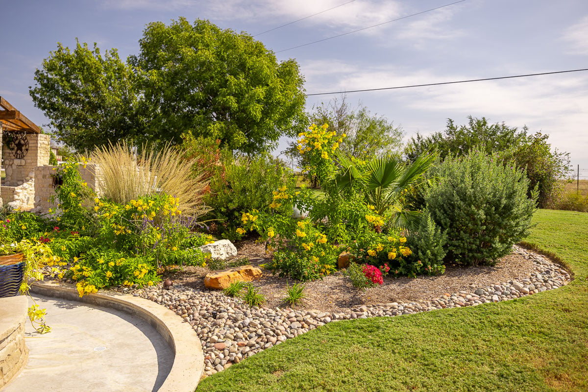 landscape beds green lawn backuyard flowers shrubs patio 