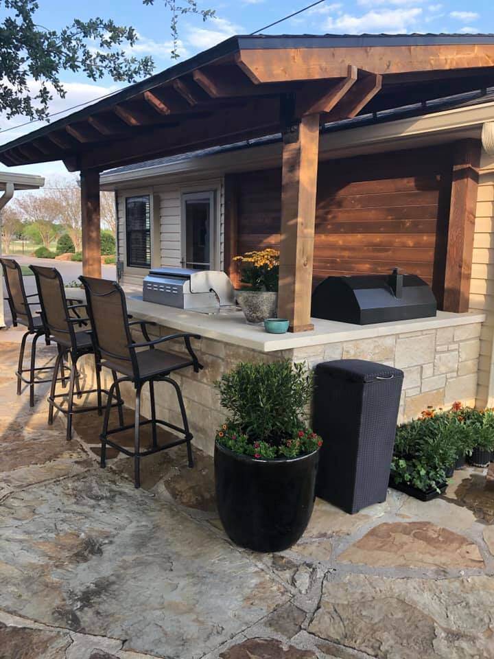 outdoor kitchen bbq grill seating bar counter stone veneer pergola flowers