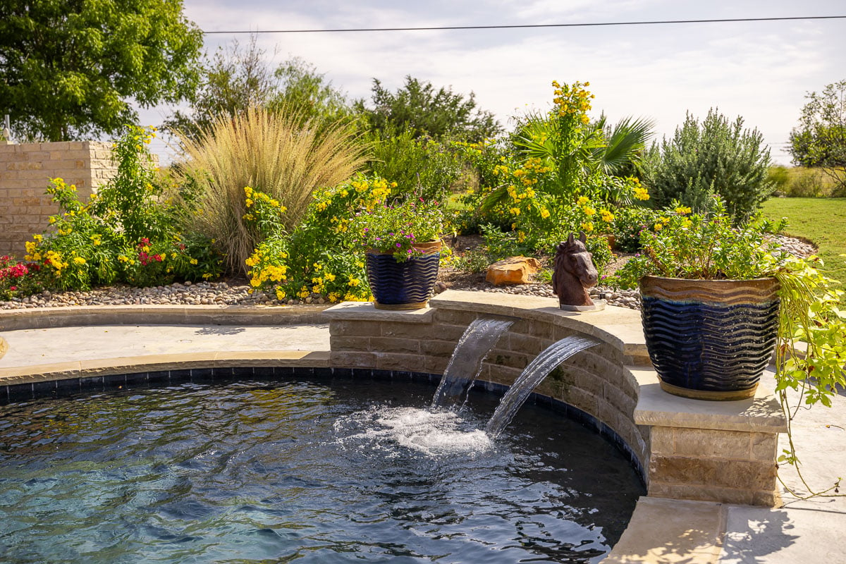 pool fountain patio landscape beds flowers backyard